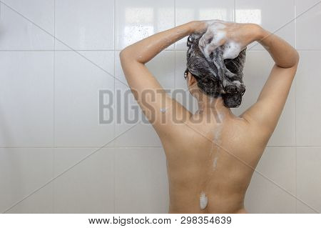 Young Asian Woman Taking A Shower And Washing Hair In White Bathroom