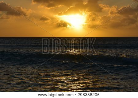 Small Waves In The Glistening Ocean At Sunset In Aruba.