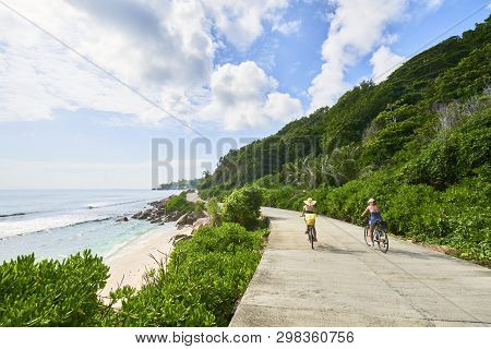 Women Cycling Around The Beautiful Beaches, La Digue Island, Sey