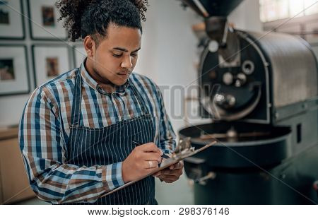 Business Owner Of A Coffee Roastery Checking A Quality Control List