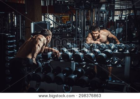 Good Looking Young Man Bodybuilder Doing Triceps Kickback Lifting Dumbbells In Front Of The Mirror L