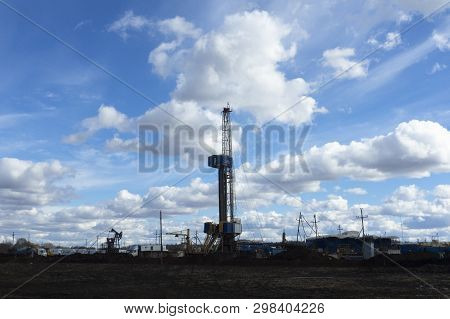 Oil And Gas Drilling Rig Onshore Dessert With Dramatic Cloudscape. Oil Drilling Rig Operation On The