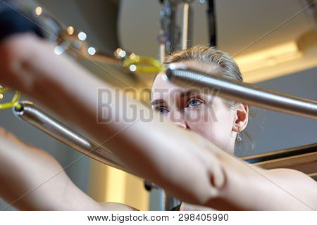 Gym Woman Pilates Stretching Sport In Reformer Bed Instructor Girl. Selective Focus On Hands