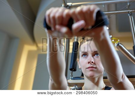 Gym Woman Pilates Stretching Sport In Reformer Bed Instructor Girl. Selective Focus On Hands