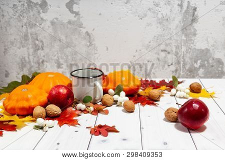 Bright Autumn Horizontal Background With Orange Pumpkins And Red Apples, Nuts, A Cup Of Tea, Green A