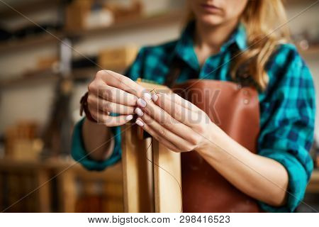 Close Up Of Young Woman Holding Thread And Needle While Making Bags And Shoes In Leatherworking Shop