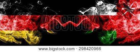 Germany Vs Oman, Omani Smoky Mystic Flags Placed Side By Side. Thick Colored Silky Smoke Flags Of De