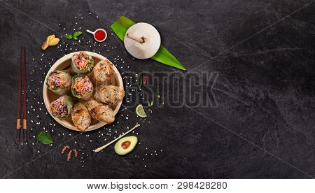 Spring rolls asian food background with various ingredients on stone background , top view. Vietnam or Thai cuisine.