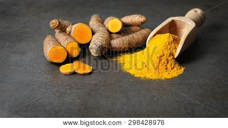 Turmeric Powder Healthy Spice Asian Food Closeup Of Turmeric Roots Sliced And A Wooden Bailer On A R