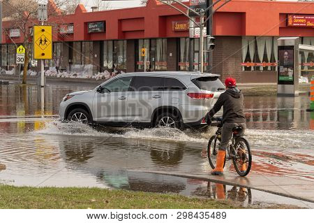 Pierrefonds-roxboro, Quebec, Canada - 29 April 2019: Car Driving On A Submerged Street During Spring