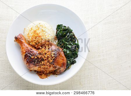 Chicken Drumstick Marinated With Spicy Chilli Sauce And Herbs, Served With Cooked Rice And Spinash.