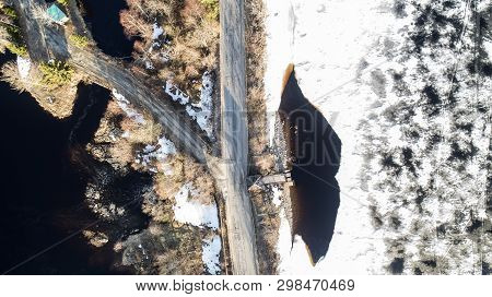 Aerial Top View Of A Branch Road, White Snowy Land And Road, Trees