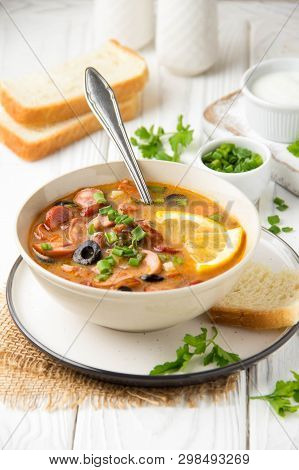 Traditional Russian Soup Solyanka With Beef, Chicken, Sausage, Lemon, Olives And Pickled Cucumber. D
