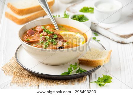 Traditional Russian Soup Solyanka With Beef, Chicken, Sausage, Lemon, Olives And Pickled Cucumber. D
