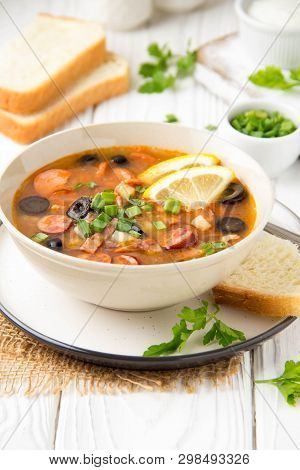 Traditional Russian Soup Solyanka With Beef, Chicken, Sausage, Lemon, Olives And Pickled Cucumber. D