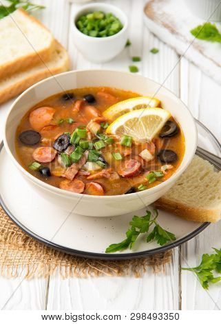 Traditional Russian Soup Solyanka With Beef, Chicken, Sausage, Lemon, Olives And Pickled Cucumber. D