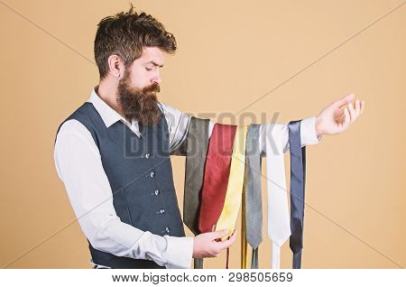 Tie The Perfect For Daily Wear. Bearded Man Choosing Neck Tie. Brutal Hipster Holding Colorful Tie C