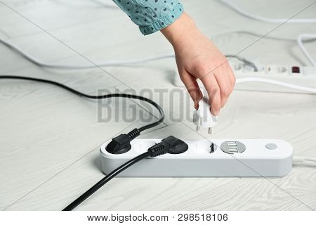 Woman Inserting Power Plug Into Extension Cord On Floor, Closeup With Space For Text. Electrician's 