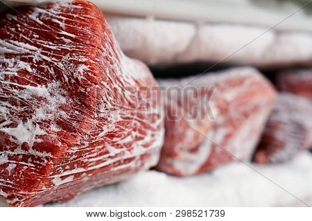 Large Pieces Of Red Meat In A Freezer With A Big Quantity Of Frozen Ice And Snow
