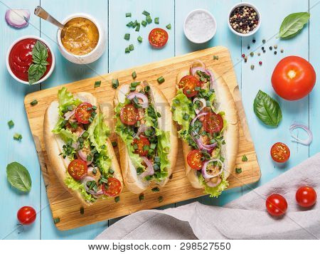 Top View Of Homemade Hotdogs With Chicken Sausages, Fresh Vegetables, Ketchup And Mustard Sauce On B