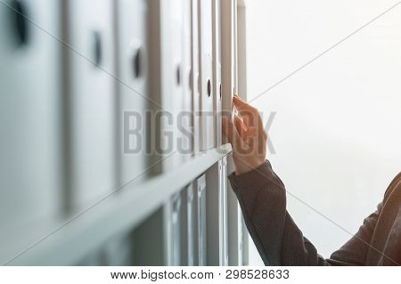 Businesswoman Browsing Through Ring Binder File Documentation Archives O The Shelf In Business Offic