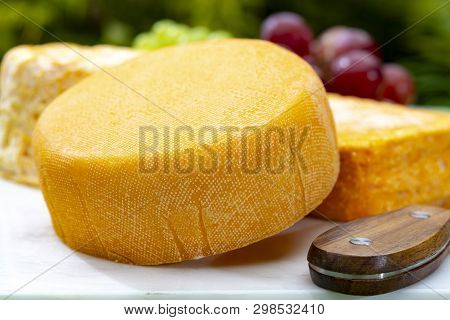 French Cheeses Collection, Yellow  Le Peche Des Bons Peres Cheese Served With Grapes On Marble Plate