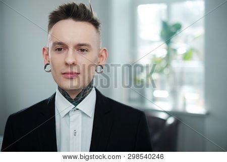 Portrait of alternative model with earplugs and tattoo