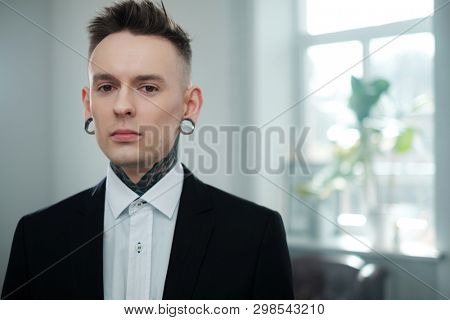 Portrait of alternative model with earplugs and tattoo