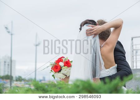 Happy Young Couple In Love. The Bride And Groom Walk. The Couple Stand, Raise His Hand Up And Look I