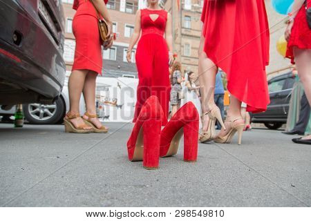 Wedding, On The Pavement Are Red Shoes In The Background Are Bridesmaids.