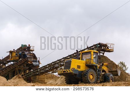 Stationary Rusty Gravitational Sand And Gravel Separator And Bucket Loader On The Background