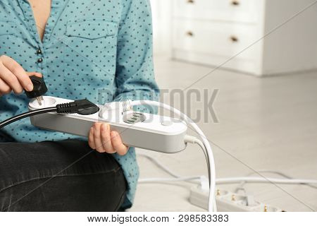 Woman Inserting Power Plug Into Extension Cord Indoors, Closeup With Space For Text. Electrician's P
