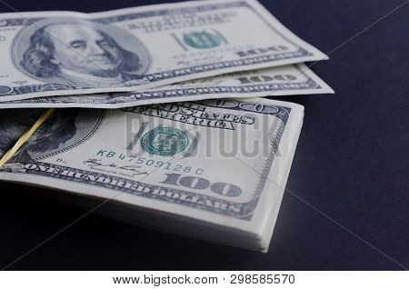 Close Up Stack Of Hundred Dollar Baknotes On A Dark Background.