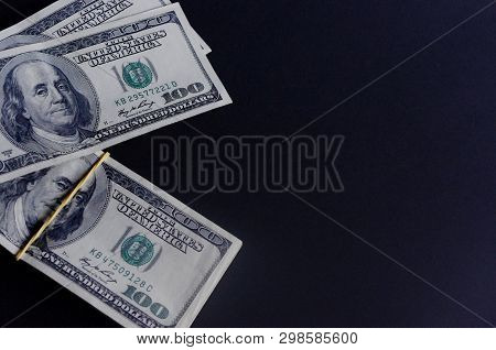 Stack Of Hundred Dollar Baknotes On A Dark Background.