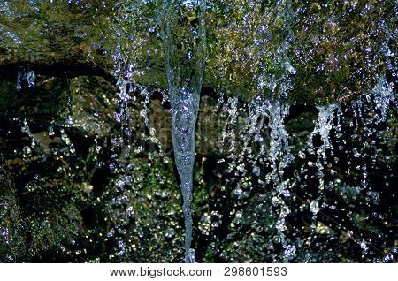 Waterfall With Drops Almost Froozen In Falling During Cold Vinter. Shiny Dark Backgruond, But Colorf