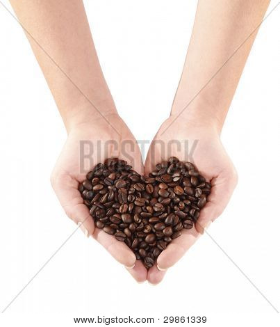 Chicchi di caffè torrefatto in mani a forma di cuore