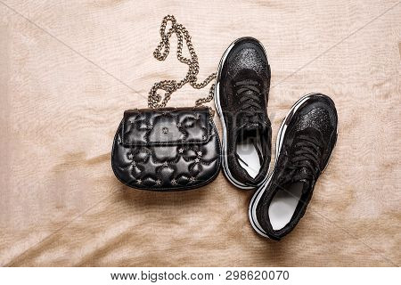 Black Sneakers On A White Thick Sole Decorated With Black Sparkles And A Black Clutch With Asterisks