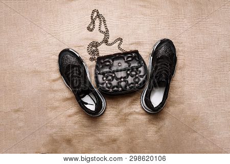 Black Sneakers On A White Thick Sole Decorated With Black Sparkles And A Black Clutch With Asterisks