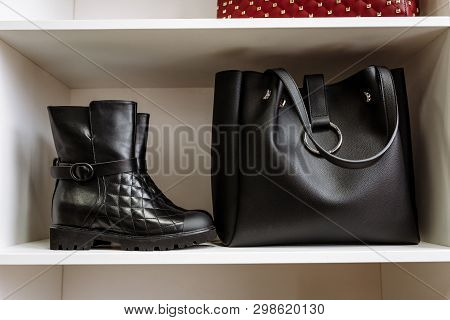 Pair Of Black Leather Shoes With Low Heels And A Black Bag On A White Shelf In The Store