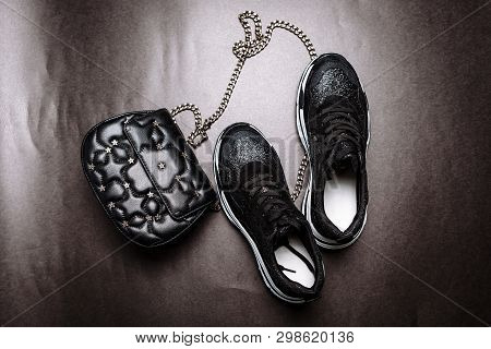 Black Sneakers On A White Thick Sole Decorated With Black Sparkles And A Black Clutch With Asterisks
