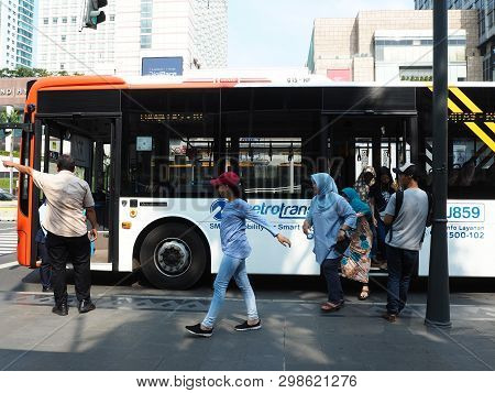 Jakarta, Indonesia - April 17, 2019: Some Passengers Getting Off The Metrotrans Bus At The Bus Stop 