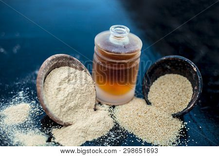 Close Up Of Organic Oil Of Poppy Seeds Or Khus Khus In A Small Glass Bottle With Raw Poppy Seeds And