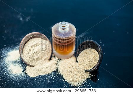 Close Up Of Organic Oil Of Poppy Seeds Or Khus Khus In A Small Glass Bottle With Raw Poppy Seeds And