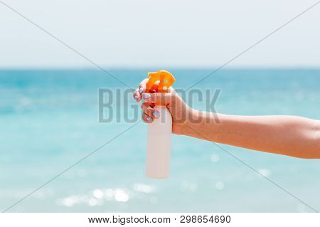 Croped Image Of Womans Hand Holding Sunblock Spray At The Beach