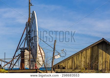 Milkovo, Kamchatka, Russia- 27 September 2014: View Of The Large Satellite Dish On The Roof Of An Ol