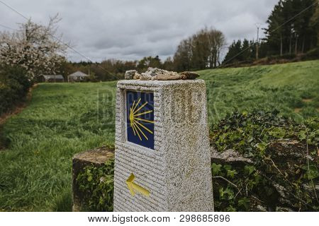 Camino De Santiago Post Made Of Stone, With Yellow Arrow And Sign.