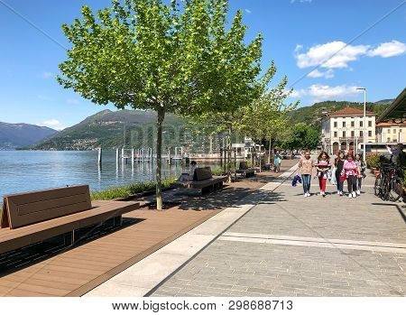 Luino, Lombardy, Italy - April 30, 2019: People Walking Along The Luino, Lakefront On The Coast Of L