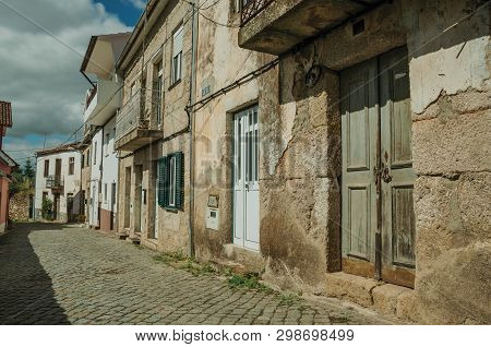 Facade Of Old Houses With Cracked Plaster Wall And Wooden Door, In A Deserted Alley At Unhais Da Ser
