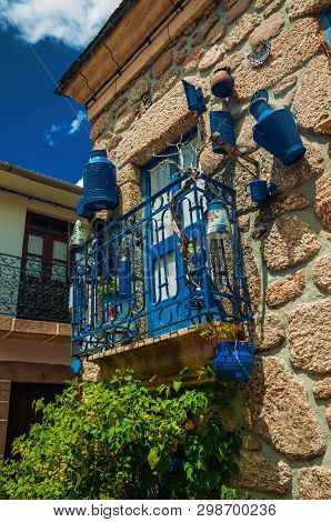 Iron Railing Balcony With Lots Of Blue Pans On Stone House Facade At Alvoco Da Serra. A Cute Village