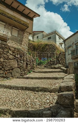 Facade Of Old Stone Houses In Cobblestone Alley On Slope With Steps, In A Sunny Day At Alvoco Da Ser